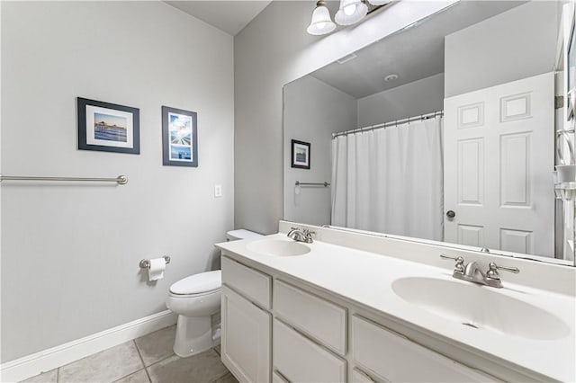 bathroom featuring tile patterned floors, toilet, baseboards, and a sink