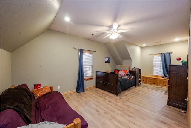 bedroom featuring lofted ceiling, visible vents, light wood-style flooring, ceiling fan, and baseboards