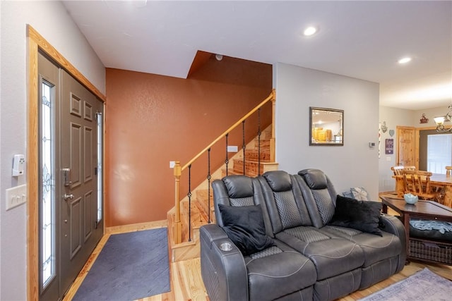 living area featuring light wood-type flooring, stairway, a notable chandelier, and recessed lighting