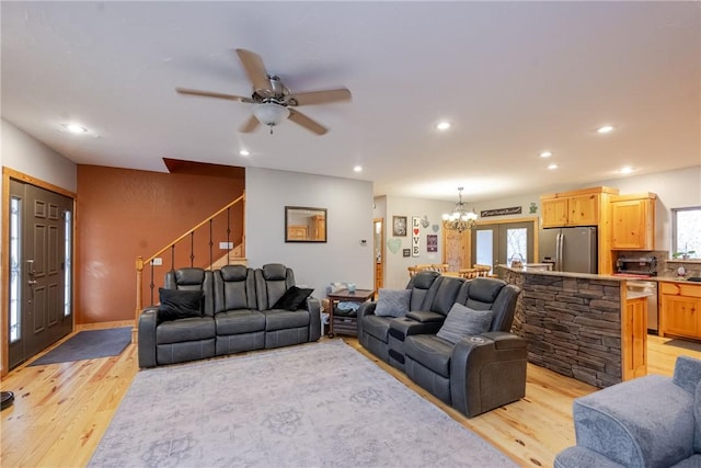 living room featuring stairway, recessed lighting, a wealth of natural light, and light wood-style flooring