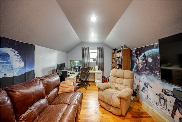 living area featuring wood-type flooring, vaulted ceiling, and a textured ceiling