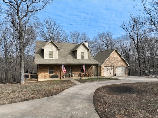 cape cod home featuring covered porch, a garage, concrete driveway, roof with shingles, and a chimney