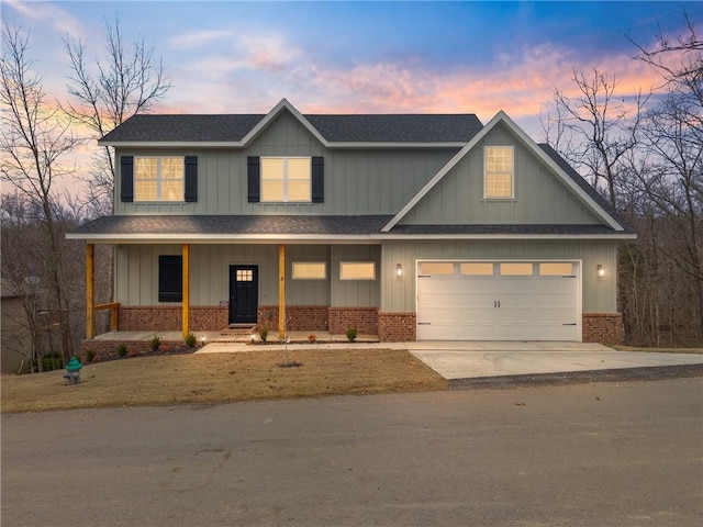 view of front of house with a shingled roof, concrete driveway, an attached garage, covered porch, and brick siding