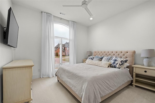 bedroom with light carpet, visible vents, and a ceiling fan