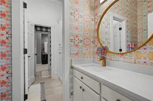 bathroom with vanity and wallpapered walls