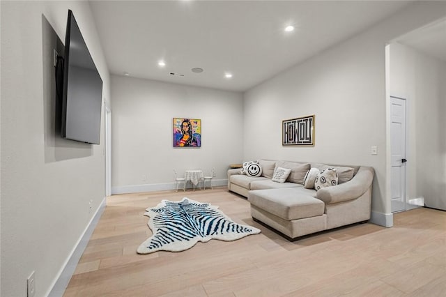 living room featuring light wood-style flooring, baseboards, and recessed lighting