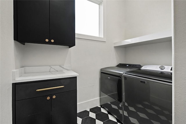 laundry room with tile patterned floors, cabinet space, baseboards, and separate washer and dryer