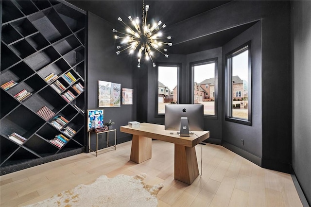 office with wood finished floors and an inviting chandelier