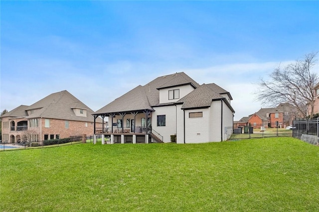 rear view of property with a fenced backyard, a lawn, and roof with shingles