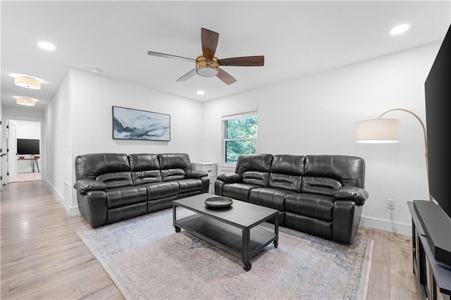 living room featuring light wood-style floors, baseboards, and recessed lighting