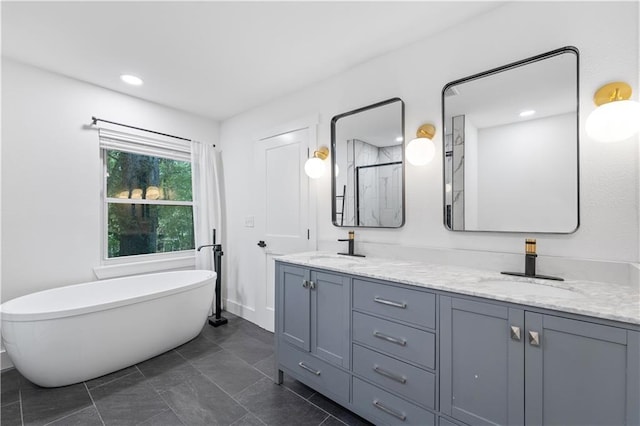 bathroom with a freestanding tub, a sink, a shower stall, and double vanity