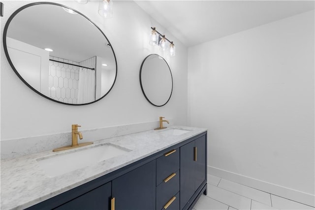 full bath featuring tile patterned floors, a sink, baseboards, and double vanity