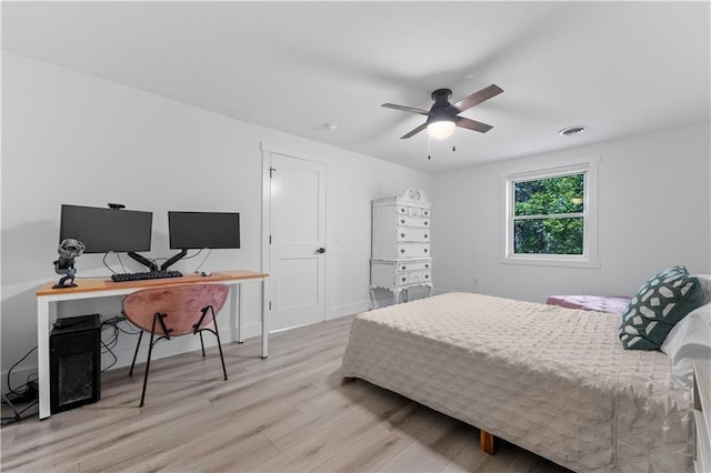 bedroom featuring ceiling fan, visible vents, and wood finished floors