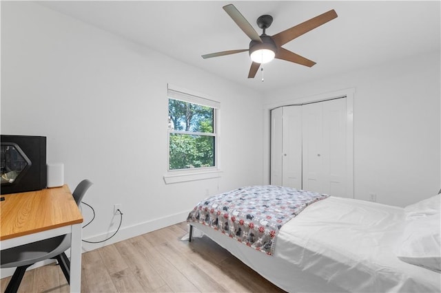 bedroom featuring ceiling fan, a closet, baseboards, and wood finished floors