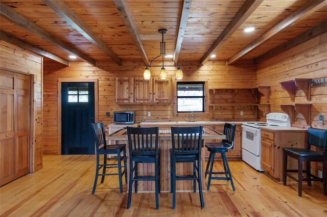 kitchen featuring electric stove, stainless steel microwave, light countertops, and beam ceiling