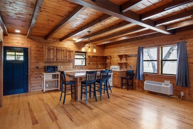 dining area with beam ceiling, wood ceiling, wood walls, and light wood finished floors