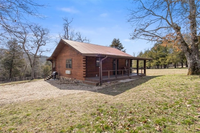 view of property exterior featuring a yard, metal roof, and log exterior