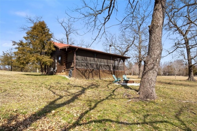 exterior space featuring a sunroom, a lawn, and log exterior