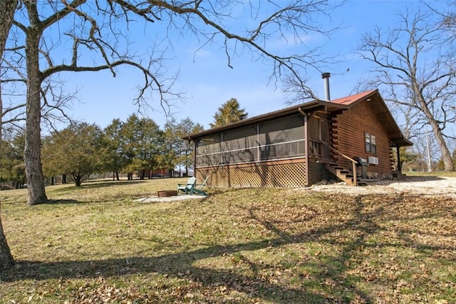 view of property exterior featuring a sunroom, log siding, and a lawn