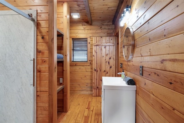 full bath with wood walls, wood ceiling, wood finished floors, and beamed ceiling