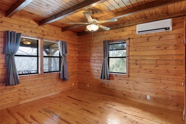 spare room with beam ceiling, a wall unit AC, light wood-style floors, wooden walls, and wooden ceiling