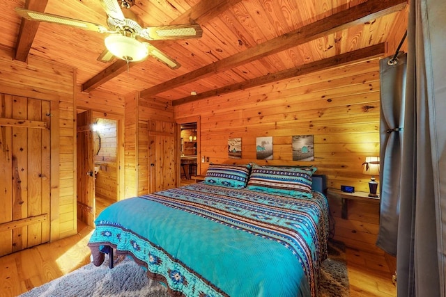 bedroom with wood ceiling, beam ceiling, wood walls, and light wood finished floors