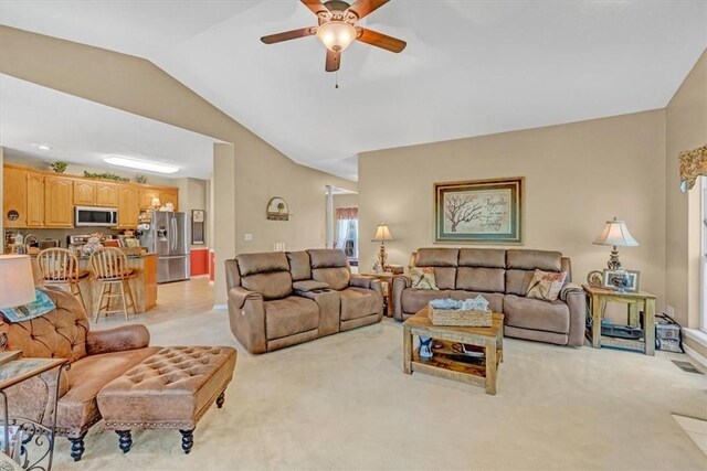 living area featuring lofted ceiling, ceiling fan, and light colored carpet