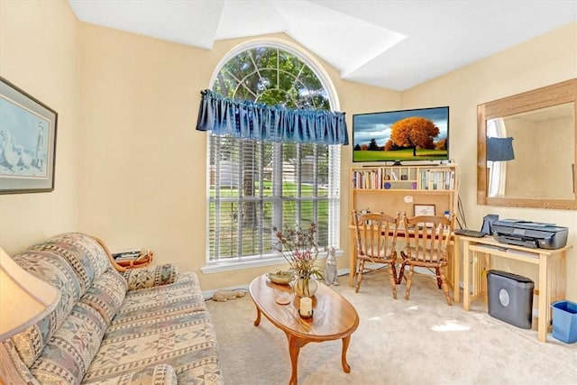 sitting room with lofted ceiling, plenty of natural light, and carpet flooring