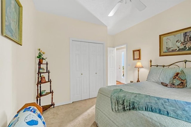 bedroom featuring lofted ceiling, ceiling fan, a closet, and carpet flooring