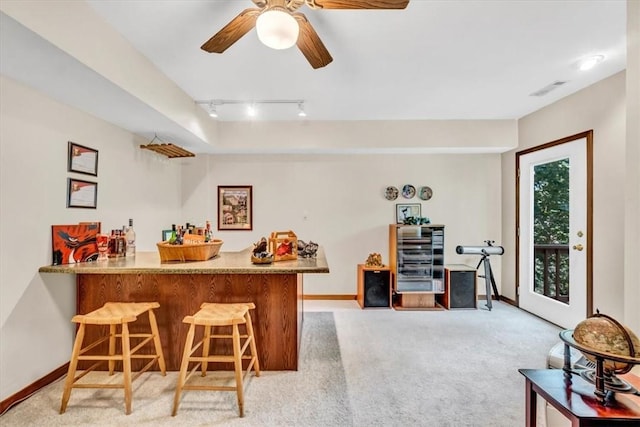 bar with light carpet, visible vents, baseboards, rail lighting, and a bar