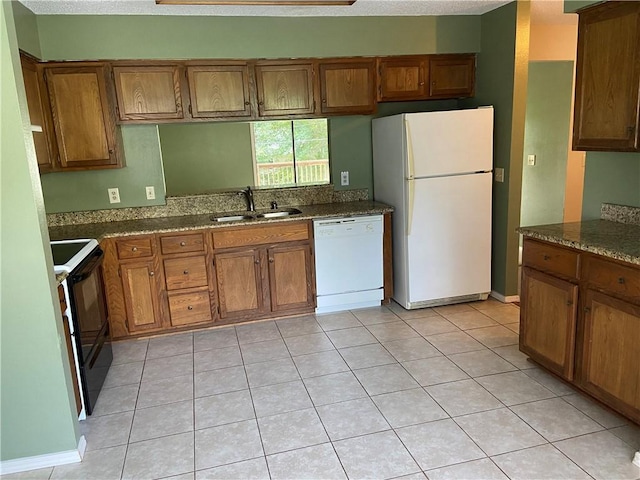 kitchen featuring white appliances, brown cabinets, and a sink