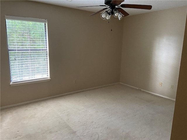 spare room featuring carpet floors, ceiling fan, a textured ceiling, and baseboards