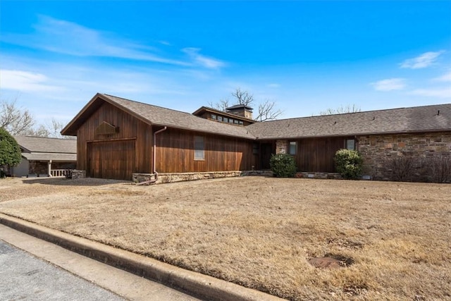 view of front of house with a garage, stone siding, and a shingled roof