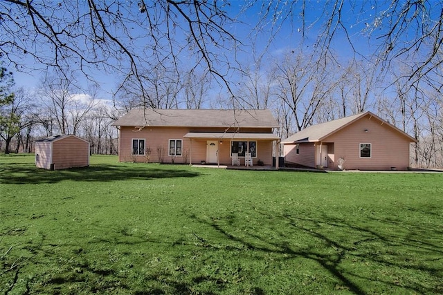 back of house featuring a yard, a patio area, a storage shed, and an outbuilding