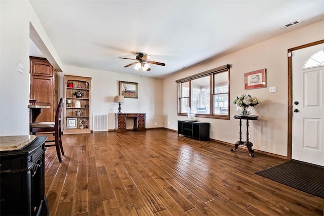 entryway featuring a fireplace, dark wood finished floors, visible vents, and a ceiling fan