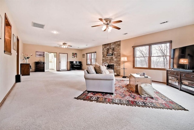 living room with a ceiling fan, visible vents, and a wealth of natural light