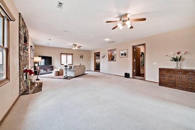 living area with baseboards, visible vents, ceiling fan, and carpet flooring