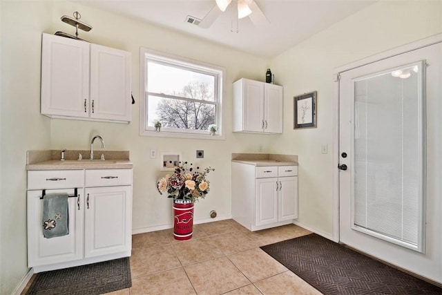 laundry area featuring light tile patterned floors, hookup for an electric dryer, washer hookup, a sink, and visible vents