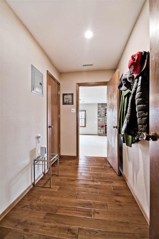 hallway with baseboards, visible vents, and hardwood / wood-style floors