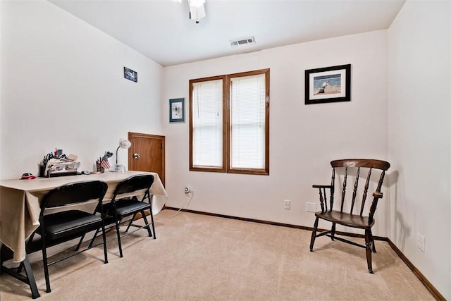 office area with baseboards, visible vents, and light colored carpet