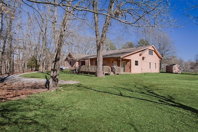 view of yard featuring a shed, an outdoor structure, and a wooden deck