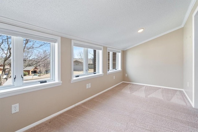 carpeted spare room with lofted ceiling, baseboards, ornamental molding, and a textured ceiling