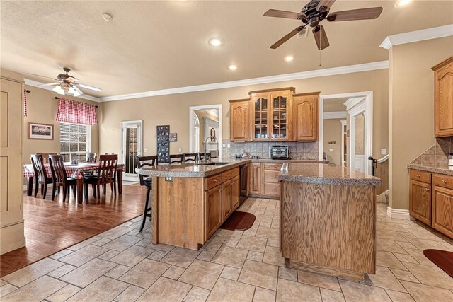 kitchen featuring a kitchen breakfast bar, a peninsula, tasteful backsplash, and a center island