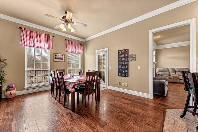 dining room with wood finished floors and crown molding