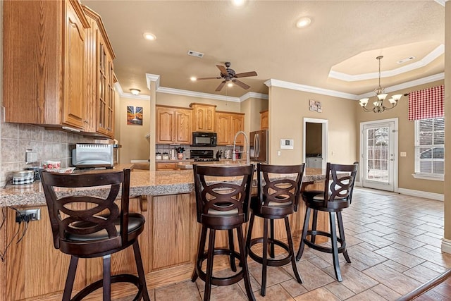 kitchen featuring visible vents, black microwave, decorative backsplash, and stainless steel fridge with ice dispenser