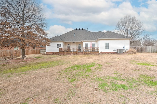 rear view of property with a shingled roof, a lawn, a fenced backyard, and a wooden deck