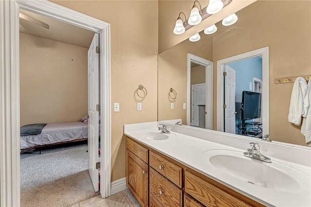 ensuite bathroom with double vanity, a sink, baseboards, and ensuite bathroom