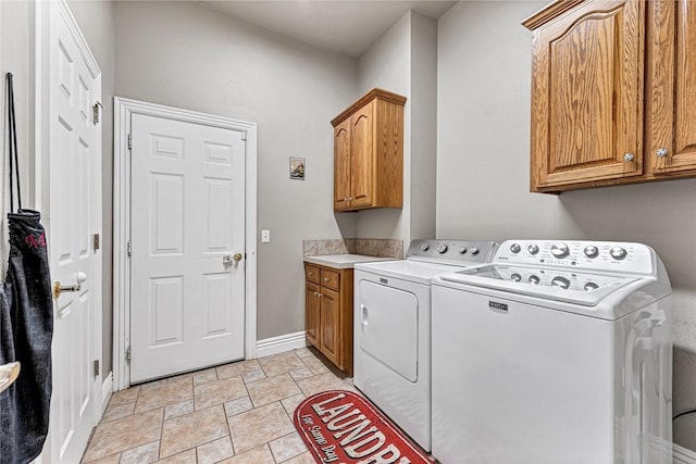 laundry room with independent washer and dryer, cabinet space, and baseboards