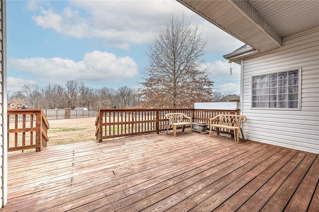 wooden terrace featuring a yard and fence