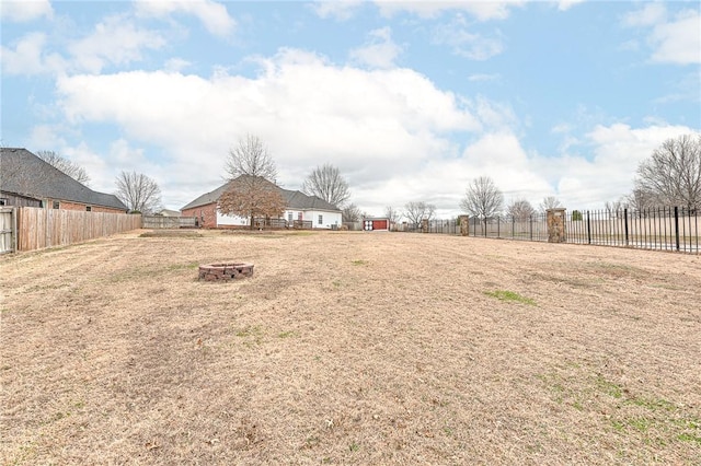 view of yard featuring a fire pit and fence